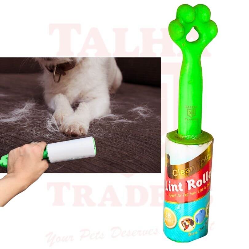 Green lint roller with paw design and a hand using it, with a cat and fur in the background.